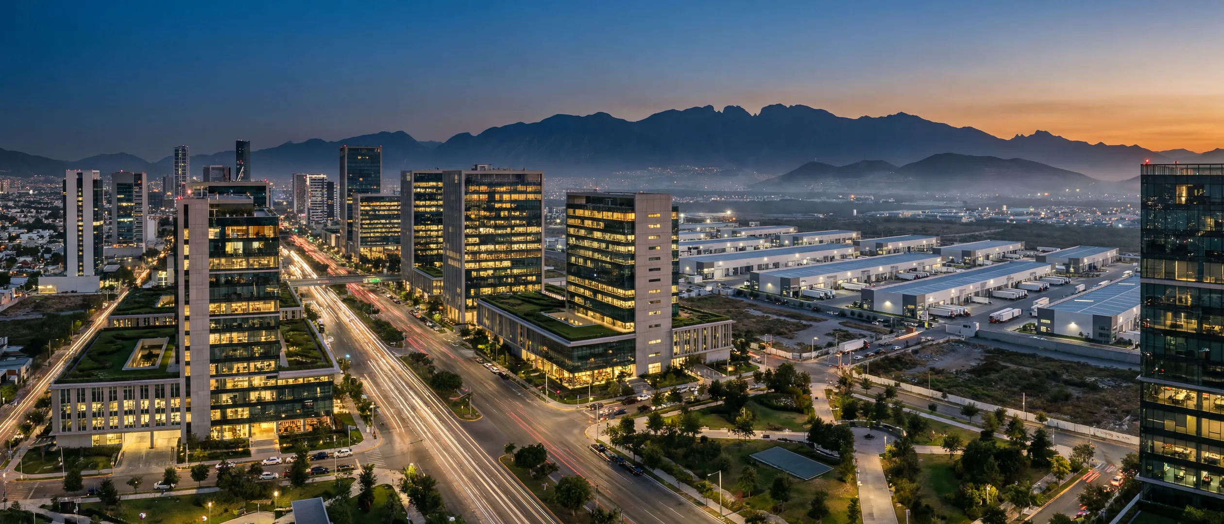 Corredor empresarial mexicano al atardecer con torres de oficinas, parque industrial y avenidas iluminadas